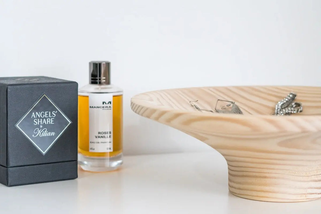 A wooden bowl sitting next to a bottle of cologne