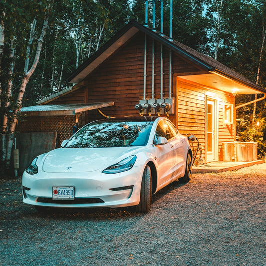 white sedan behind of brown log house