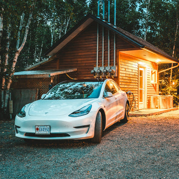 white sedan behind of brown log house