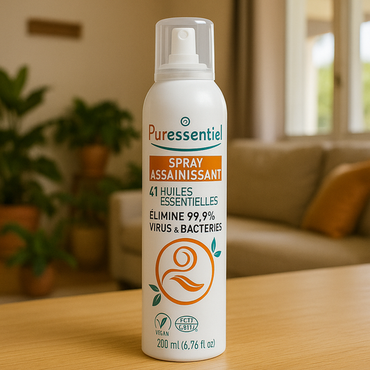 Puressentiel Spray Assainissant - 41 Huiles Essentielles posé sur une table en bois dans un salon lumineux. Purificateur d'air naturel pour maison saine.