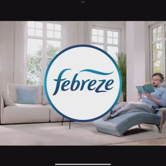 Publicité FEBREZE mettant en scène un homme détendu dans un salon lumineux, illustrant l'effet apaisant du Désodorisant Électrique 3Volution.